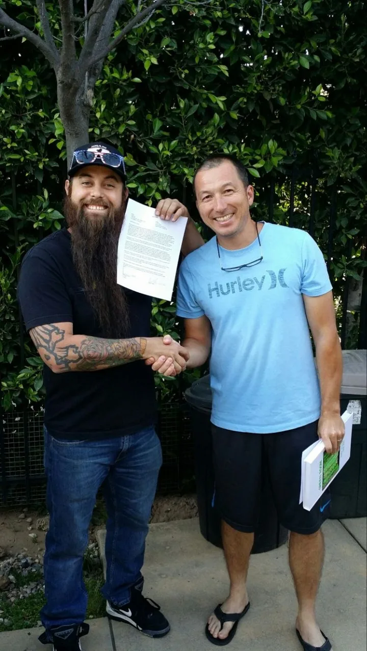 Chris "Tice" Theis and Randy Grube shake hands over the signed XDL sale agreement, 2016